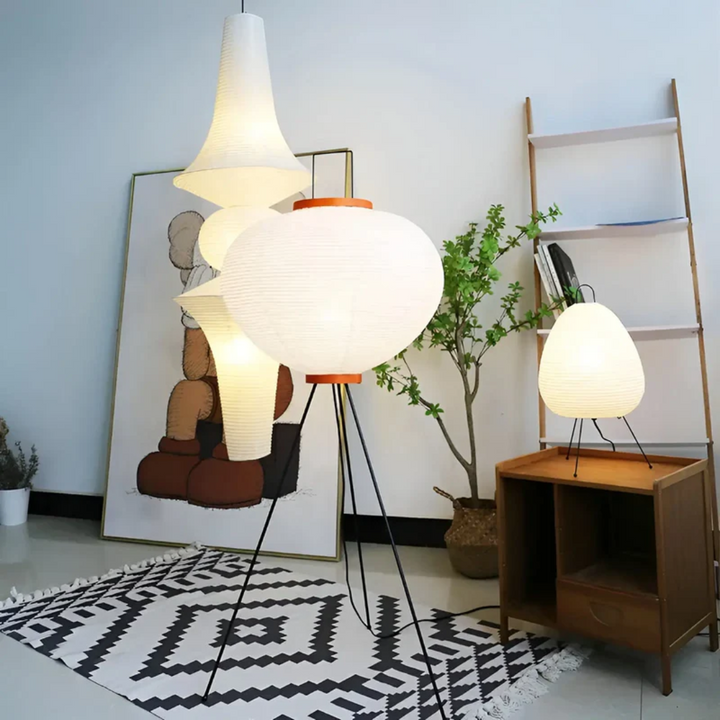 Moderne Stehlampe aus Papier, weiß, auf Teppich mit geometrischem Muster, neben Holzregal.