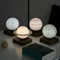 Vier planetenförmige LED-Lampen auf Holzsockeln, leuchtend auf einem Tisch.