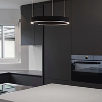 Moderne schwarze Küche mit LED-Ring-Pendelleuchte, Einbauofen und grauer Arbeitsplatte.