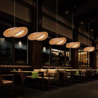Moderne hängende Rattanlampen in einem stilvollen Restaurant, warmes Licht, elegante Atmosphäre.