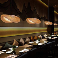 Moderne Restaurantbeleuchtung, hängende Rattanlampen, stilvolles Interieur, warme Atmosphäre.