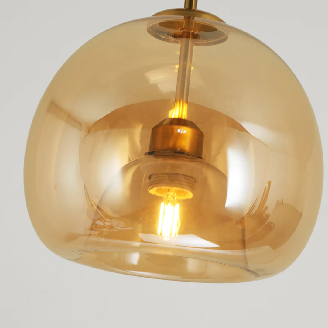 Moderne Pendelleuchte aus bernsteinfarbenem Glas mit sichtbarem Glühfaden, elegantes Design.