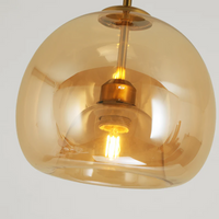 Moderne Pendelleuchte aus bernsteinfarbenem Glas mit sichtbarem Glühfaden, elegantes Design.