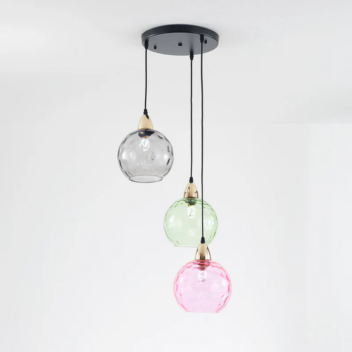 Moderne dreifarbige Pendelleuchte mit Glaslampenschirmen in Schwarz, Grün und Rosa.