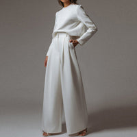 Frau in weißem Anzug, weite Hose, elegantes Design, modische Damenbekleidung.