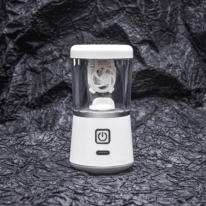 Tragbarer weißer Mini-Mixer mit USB-Ladefunktion auf schwarzem Hintergrund.