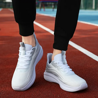 Weiße Sportschuhe auf roter Laufbahn, atmungsaktiv, ideal für Laufen und Fitness.
