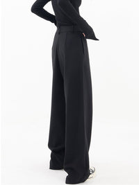 Frau trägt schwarze, asymmetrische Baggy-Hose, modisch, elegant, Damenmode, Streetwear.