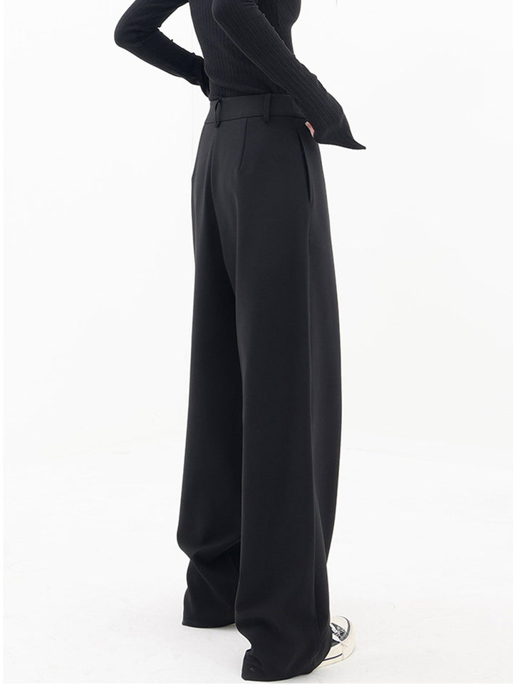 Frau trägt schwarze, asymmetrische Baggy-Hose, modisch, elegant, Damenmode, Streetwear.
