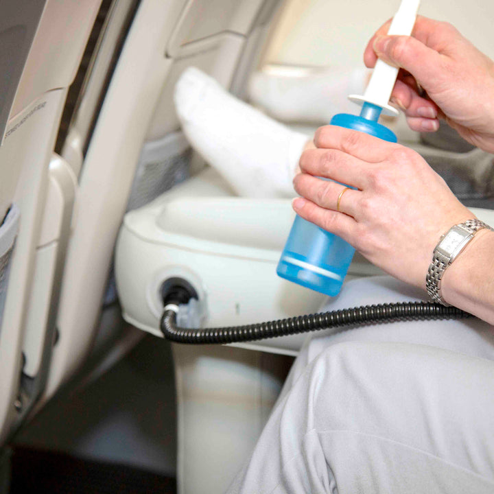 Person pumpt aufblasbares Kinderbett im Flugzeug auf, blau, tragbar, Reisebett, bequem.