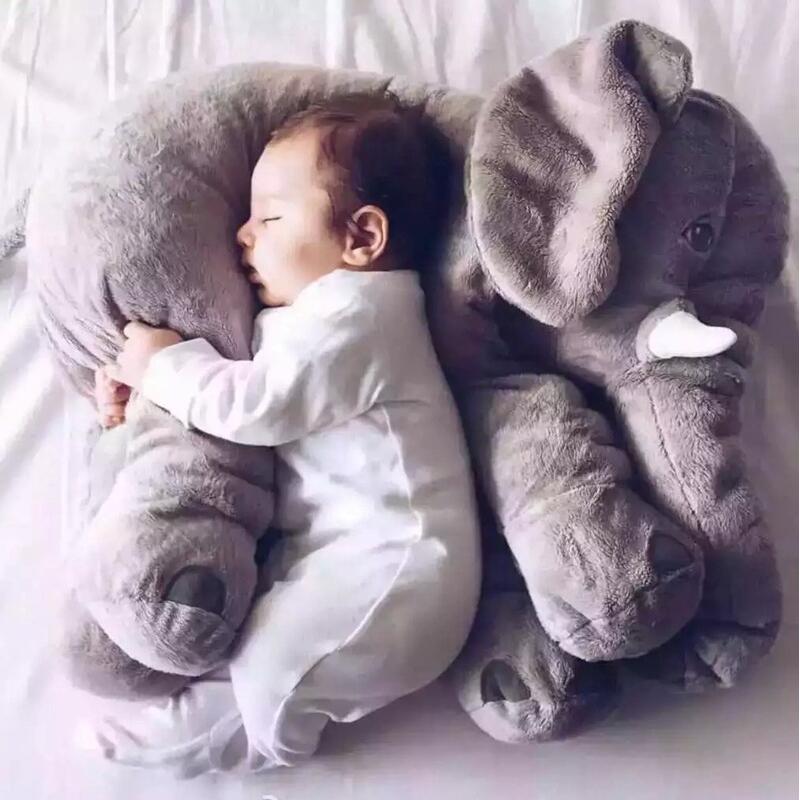 Kleinkind schläft auf grauem Elefanten-Kuscheltier, Babybett, Plüsch, gemütlich, Schlafhilfe.