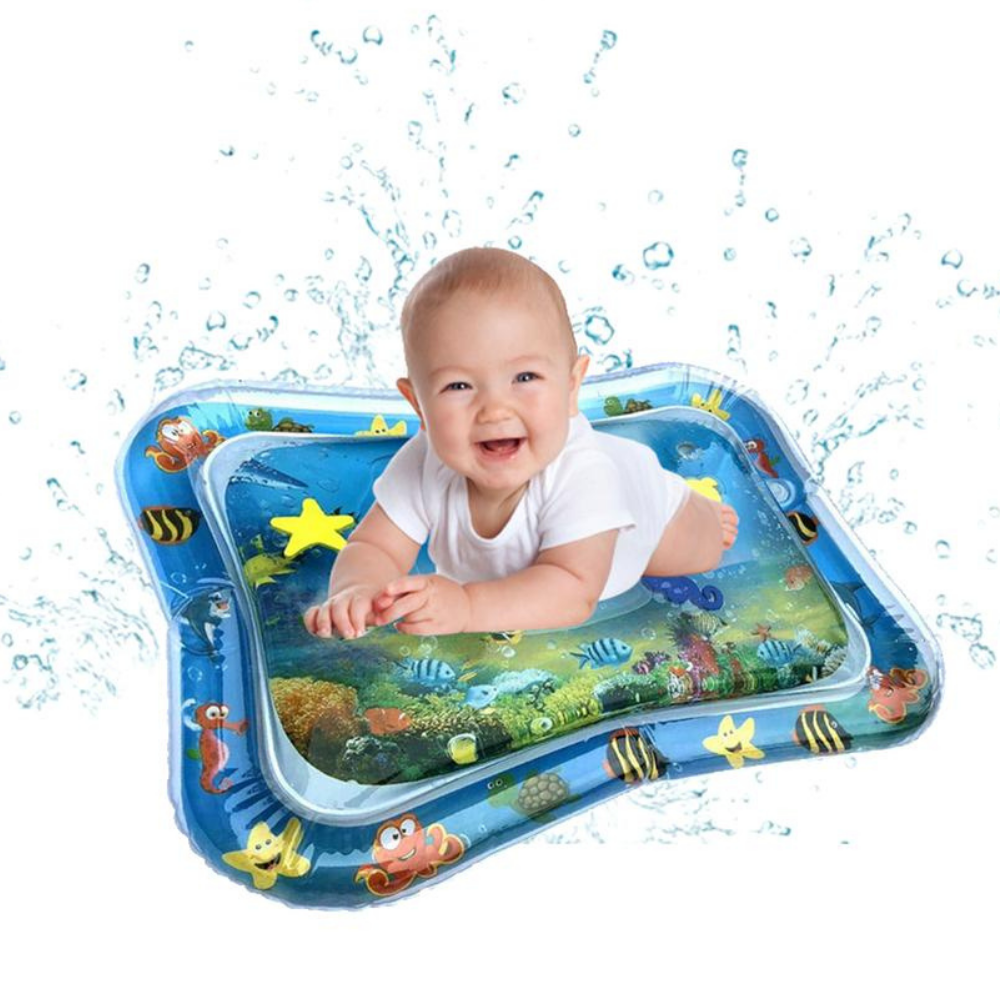 Lächelndes Baby auf blauem Wasserspielmatte mit Meeresmotiven und spritzendem Wasser.