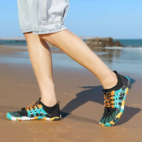 Person trägt bunte Wasserschuhe am Strand, ideal für Outdoor-Aktivitäten und Wassersport.