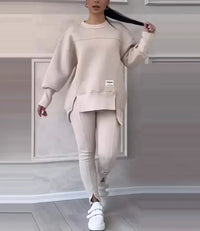 Frau in beigem Oversize-Sweatshirt und Leggings, modisches Freizeitoutfit, weiße Sneaker.