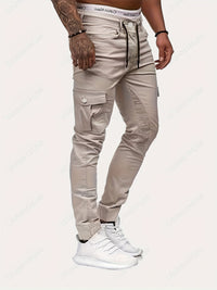 Mann in beigen Cargo-Jogginghosen mit Taschen, Calvin Klein Unterwäsche, weiße Sneaker.