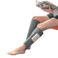 Person mit grauem Beinmassagegerät, liest ein Buch, Entspannung, Wellness, Zuhause.