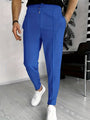 Mann in blauer Jogginghose und weißen Sneakers im modernen Wohnzimmer.