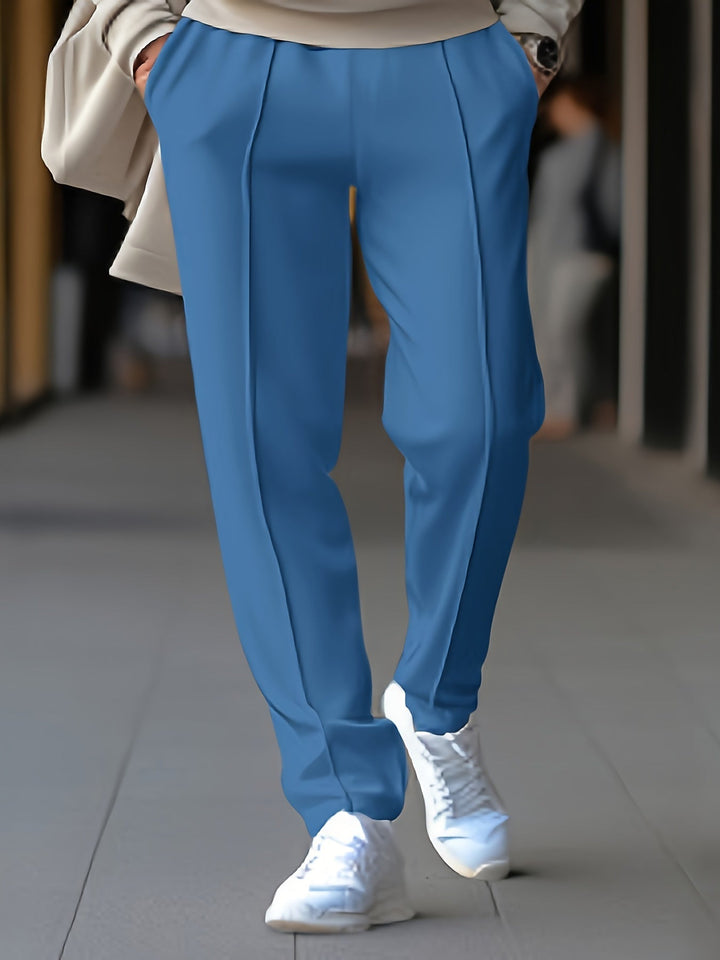 Blaue Damenhose, elegant, mit Bügelfalte, kombiniert mit weißen Sneakers, modisch, streetwear.