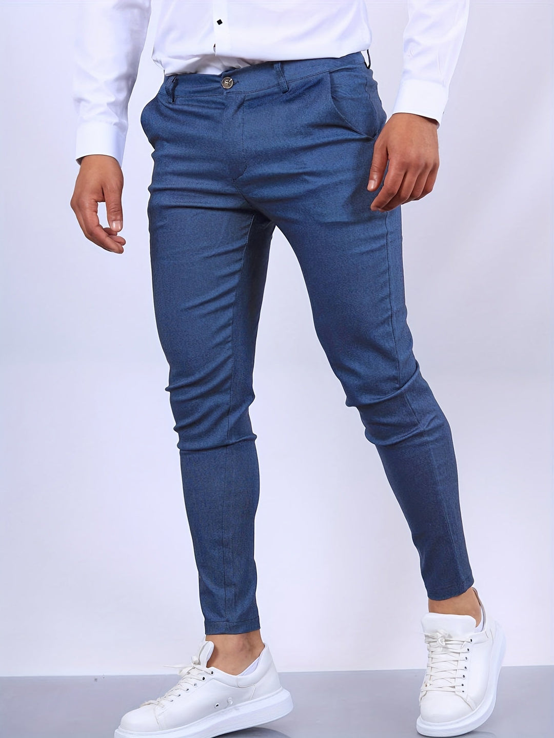 Mann in blauer Slim-Fit-Hose und weißen Sneakers, modische Herrenbekleidung.