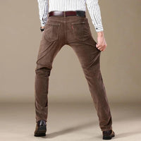Mann in brauner Cordhose, Rückansicht, gestreiftes Hemd, modische Herrenbekleidung.