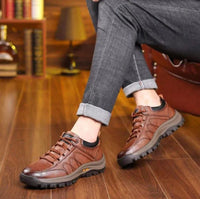 Braune Herrenschuhe aus Leder, lässig, robust, auf Holzboden, ideal für Freizeitkleidung.