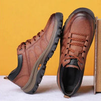 Braune Wanderschuhe aus Leder mit rutschfester Sohle vor gelbem Hintergrund.