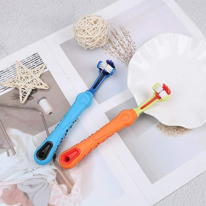 Zwei bunte Kinderzahnbürsten auf einem Tisch, blau und orange, mit weichen Borsten.