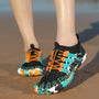 Bunte Wasserschuhe mit orangefarbenen Schnürsenkeln, ideal für Strandaktivitäten.