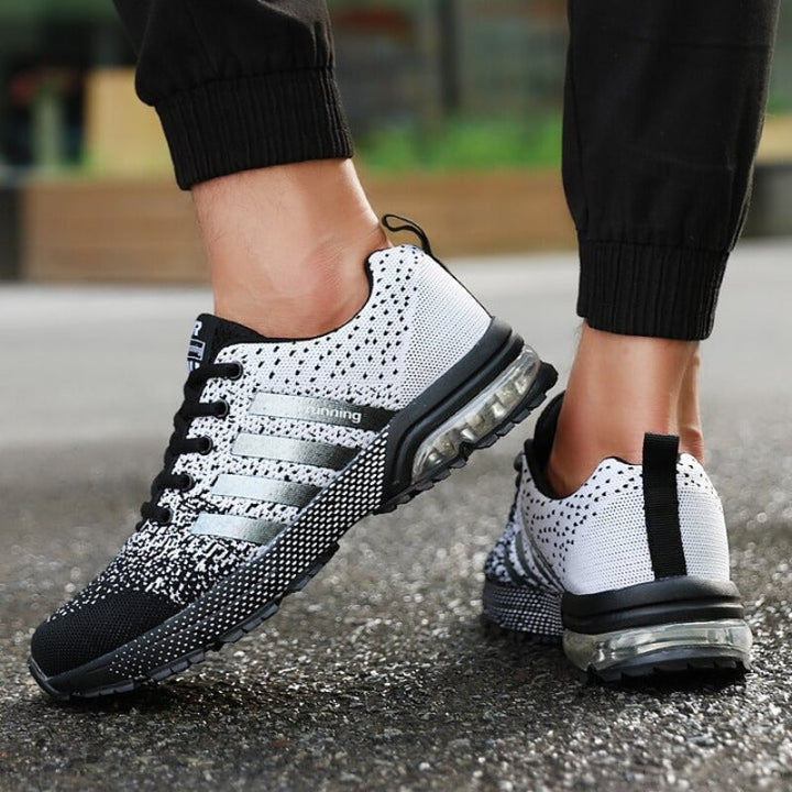 Schwarz-weiße Laufschuhe mit Luftpolstersohle, atmungsaktiv, ideal für Sport und Freizeit.