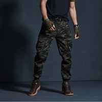 Mann in Camouflage-Cargohose, schwarze T-Shirt, braune Stiefel, taktische Handschuhe.