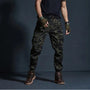 Mann in Camouflage-Cargohose, schwarze T-Shirt, braune Stiefel, taktische Handschuhe.