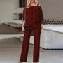 Frau in eleganter, weinroter Chiffon-Hose und Tunika, Abendmode, schulterfrei, mit Clutch.