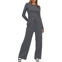 Frau in grauem Freizeitanzug, Langarmshirt und Hose, modisch, bequem, Damenbekleidung.