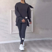 Damen-Sportanzug, dunkelgrau, langärmelig, mit weißen Sneakers, lässige Freizeitmode.