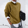 Damenpullover aus Wolle, beige, lässig, Herbstmode, kombiniert mit weißer Bluse und schwarzer Tasche.