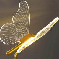 Moderne LED-Wandleuchte in Schmetterlingsform, transparentes Acryl, goldener Sockel.