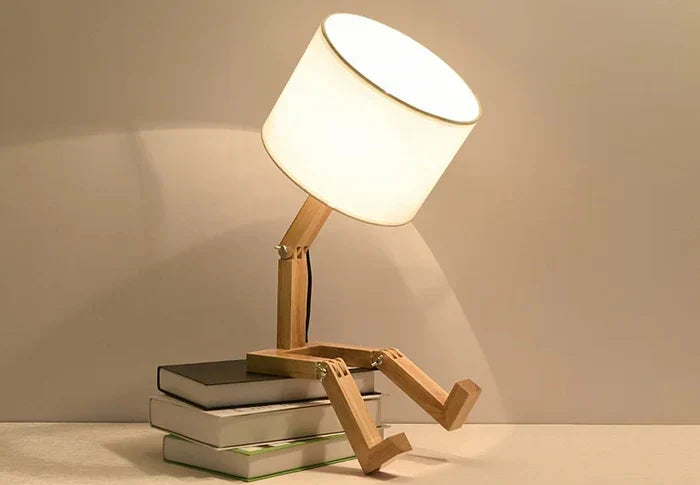 Holzlampensockel mit weißem Lampenschirm, sitzt auf gestapelten Büchern, modernes Design.