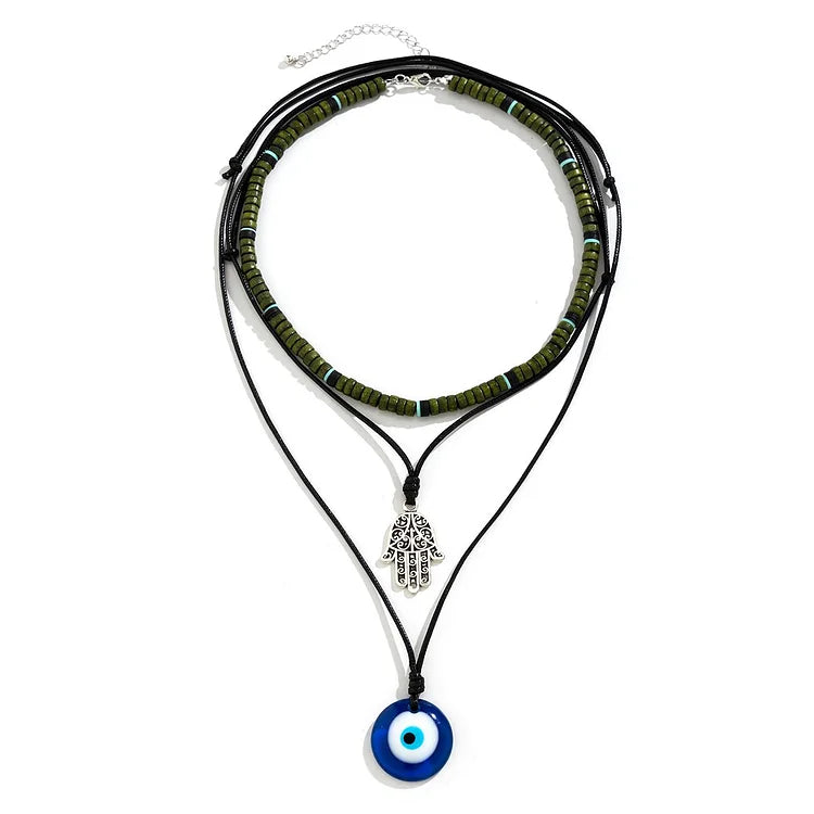 Dreifach-Halskette mit blauen Glasperlen, Hamsa-Anhänger und schwarzem Lederband.