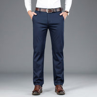 Mann in blauer Anzughose, weißem Hemd, braunem Gürtel und Schuhen, Business-Look.