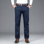 Mann in blauer Anzughose, weißem Hemd, braunem Gürtel und Schuhen, Business-Look.