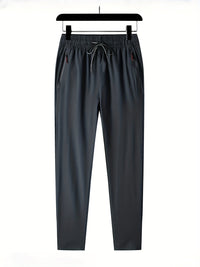 Dunkelgraue Jogginghose, elastischer Bund, Kordelzug, Reißverschlusstaschen, Herrenmode.