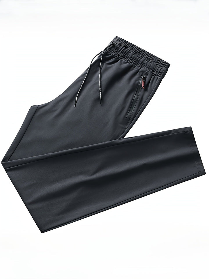 Schwarze Jogginghose, elastischer Bund, Kordelzug, Reißverschlusstasche, Sportbekleidung.