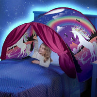 Mädchen im Bett mit Einhorn-Betthimmel, Regenbogen, lila Vorhänge, Nacht-Sternenhimmel.