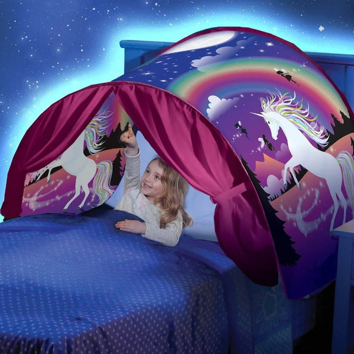 Mädchen im Bett mit Einhorn-Betthimmel, Regenbogen, lila Vorhänge, Nacht-Sternenhimmel.