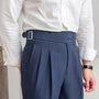 Mann in weißem Hemd und blauer Anzughose mit Schnalle, elegante Herrenmode.