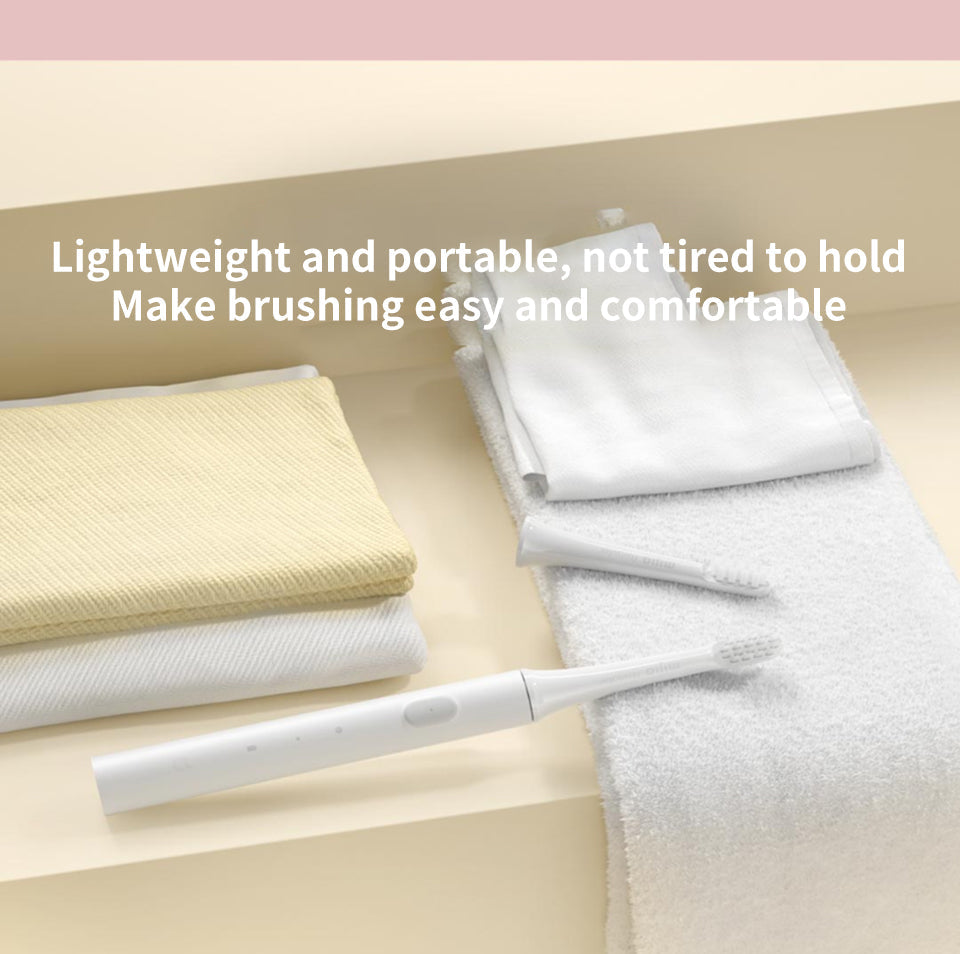 Elektrische Zahnbürste weiß, modern, mit Ersatzbürstenkopf auf Handtuch im Badezimmer.