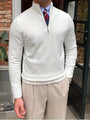 Eleganter weißer Herrenpullover mit Reißverschluss, kombiniert mit beiger Hose und Krawatte.