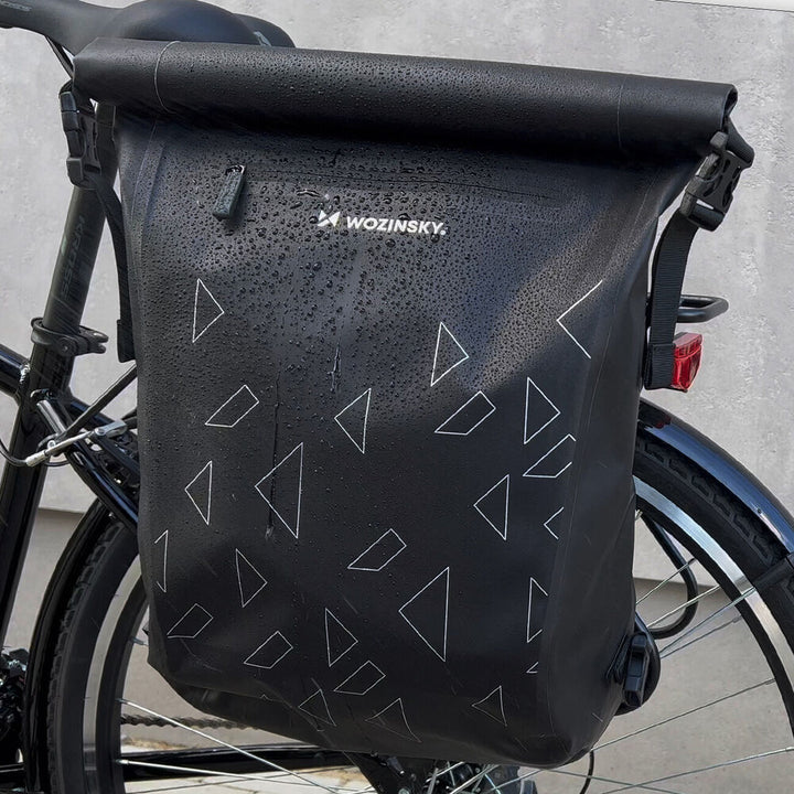 Schwarze wasserdichte Fahrradtasche mit Dreiecksmuster, befestigt am Fahrradträger.