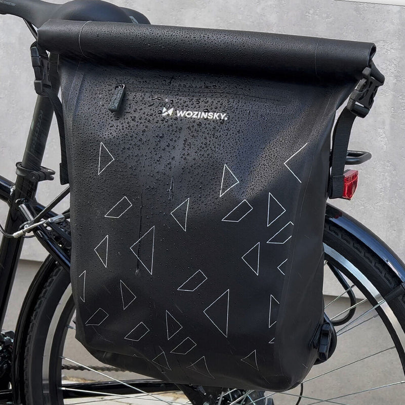 Schwarze wasserdichte Fahrradtasche mit Dreiecksmuster, befestigt am Fahrradträger.