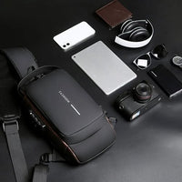 Schwarze Umhängetasche mit Kamera, Kopfhörer, Smartphone und Tablet auf schwarzem Hintergrund.